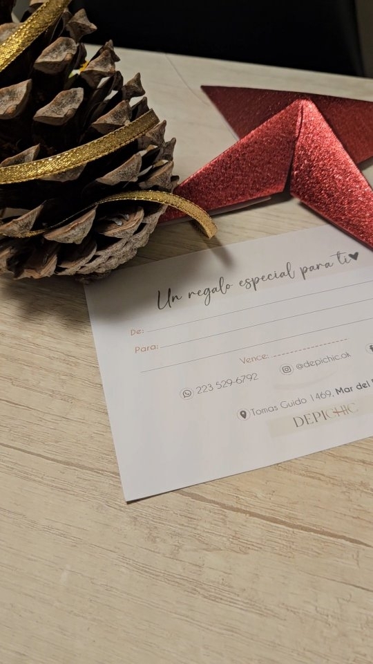 La gift card impresa de Depichic, «Un regalo especial para ti», sobre una mesa junto a una piña y una estrella roja